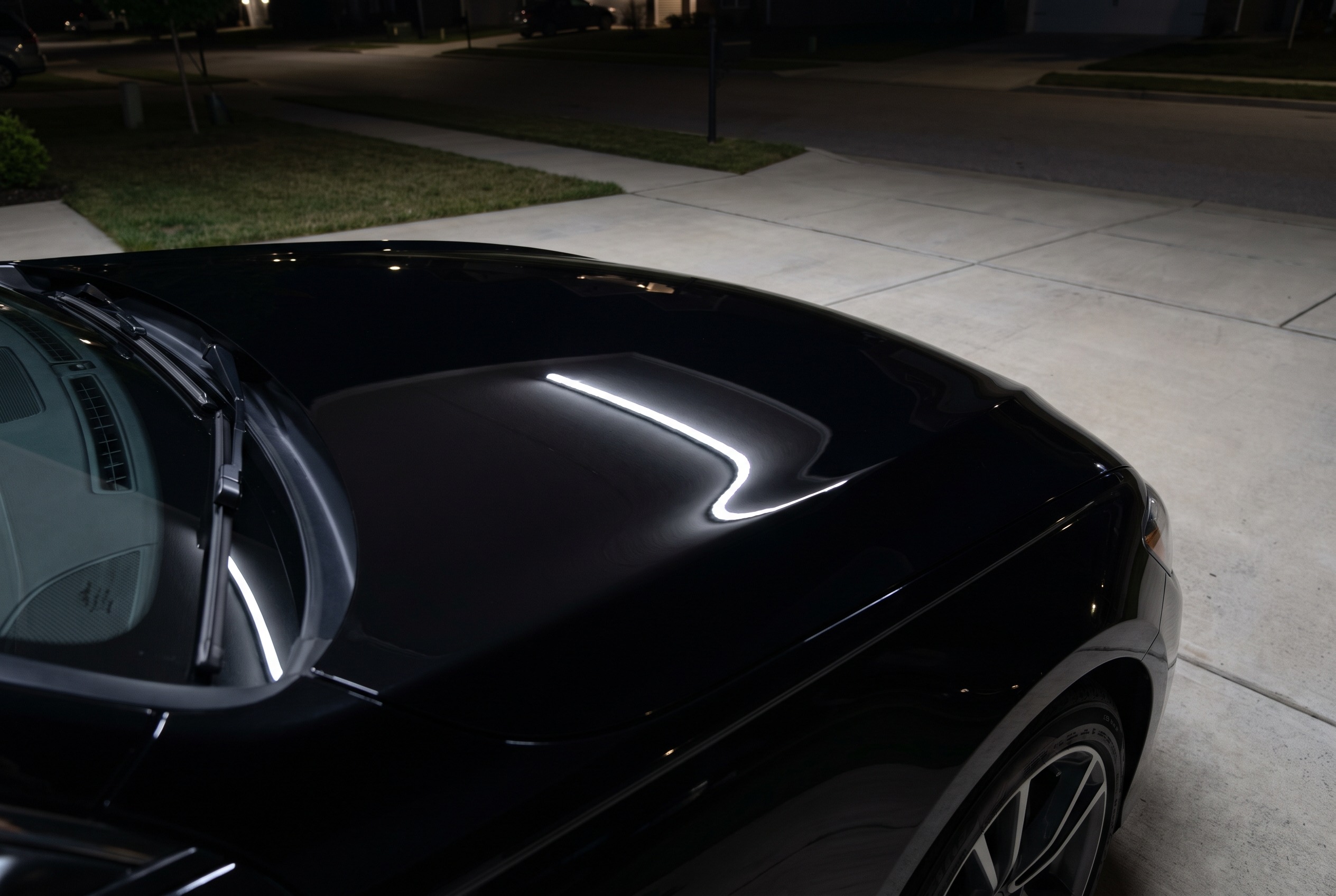 The same black hood after multi-stage correction and ceramic coating, mirror gloss